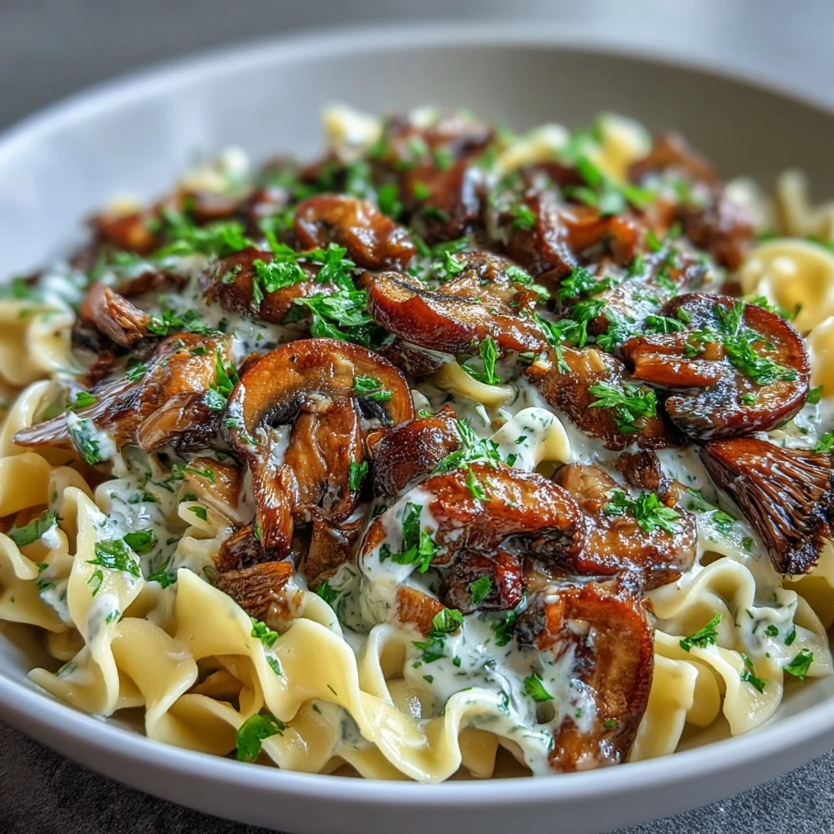 Creamy Mushroom Stroganoff served over wide fettuccine noodles, topped with fresh parsley and black pepper.