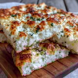 Freshly cooked fluffy cottage cheese flatbread bubbles in a skillet, releasing savory garlic and herb aromas with a tender crumb.