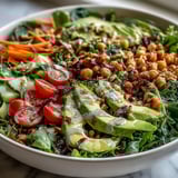 Healthy vegan Mixed Greens Power Bowl served in a rustic bowl, dressed with zesty lemon vinaigrette.