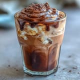 Rich, creamy chocolate foam floats on bold cold brew coffee, garnished with chocolate drizzle for extra indulgence.