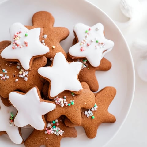 Freshly baked gingerbread cookies, warm brown and spiced, ready for icing and sprinkles.