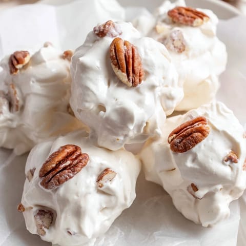 A close-up of a batch of homemade divinity, showing the sweet, pillowy texture and nuts.