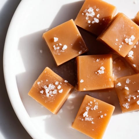 Close-up of freshly cut sea salt caramels showcasing a perfectly chewy texture with a shiny glaze.