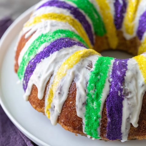 A beautiful, freshly baked King Cake, decorated with festive purple, green and gold sugars.