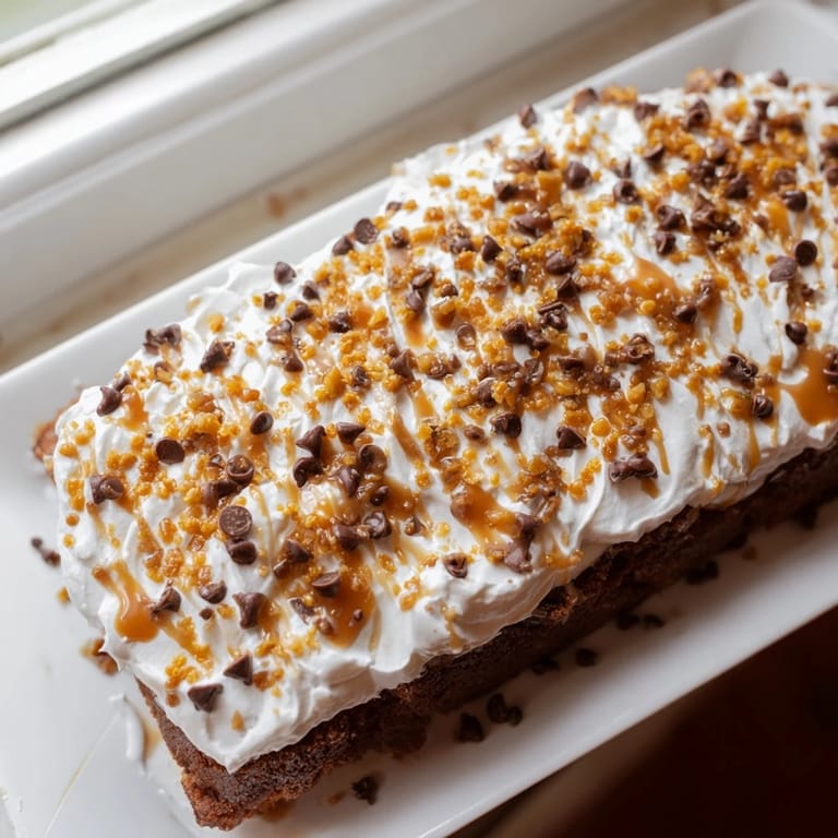 A close-up of a moist Better Than Sex Cake showcasing caramel drizzle and toffee bits.