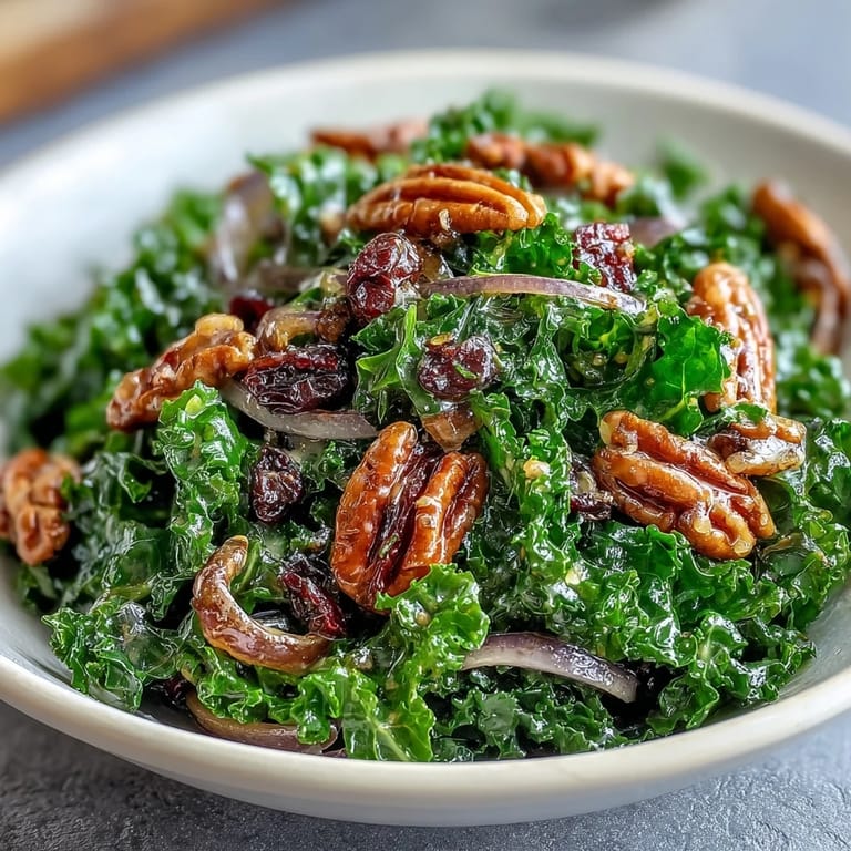 Hearty vegetarian kale salad with a sweet and tangy maple mustard vinaigrette, served warm with toasted walnuts.