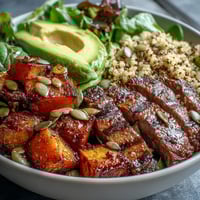 Butternut squash steak bowls feature caramelized squash, smoky steak, avocado, and pepitas on fluffy quinoa.